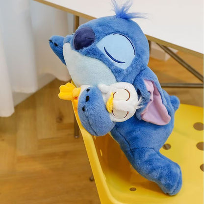 Jouet en Peluche Stitch avec Canard - Animal en Peluche Doux de Couleur Bleue dans une Position d'Étreinte, Coussin Officiellement Licencié pour Enfants, Filles, Femmes, Cadeau d'Anniversaire, Peluches Rembourrées