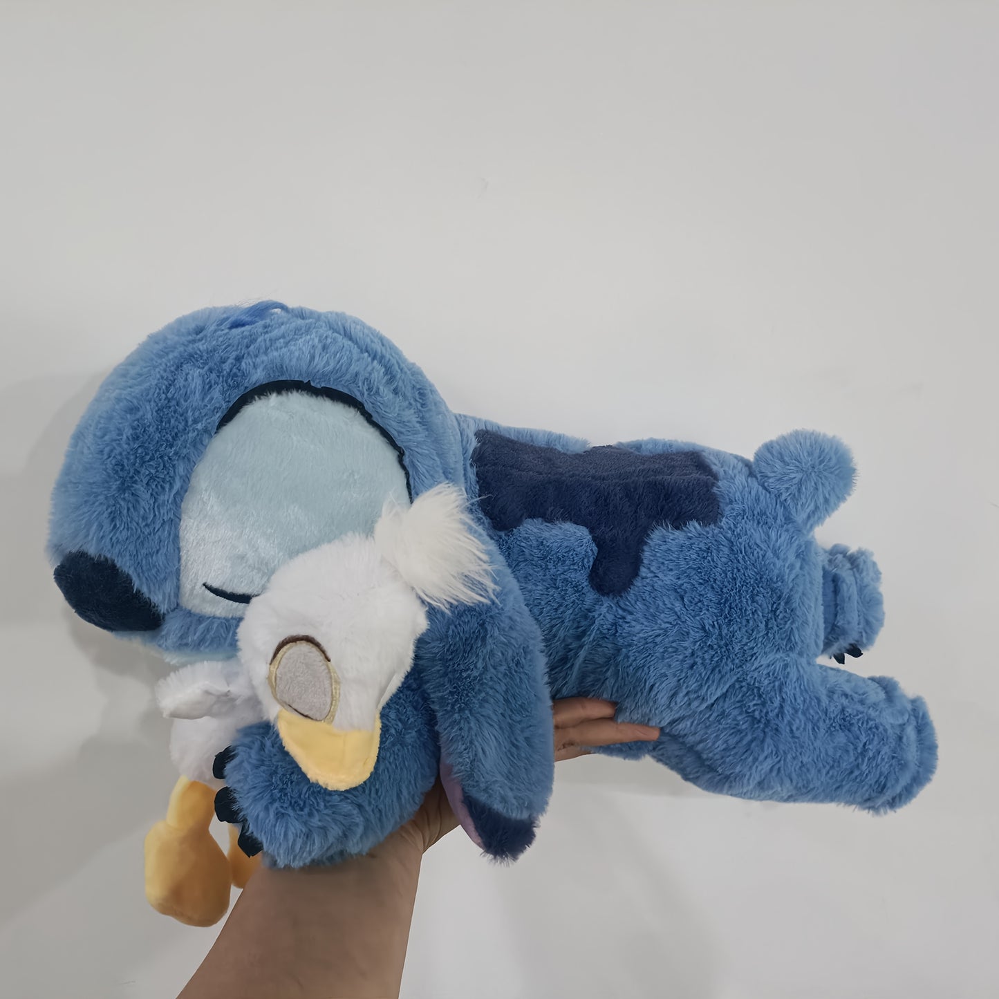 Jouet en Peluche Stitch avec Canard - Animal en Peluche Doux de Couleur Bleue dans une Position d'Étreinte, Coussin Officiellement Licencié pour Enfants, Filles, Femmes, Cadeau d'Anniversaire, Peluches Rembourrées